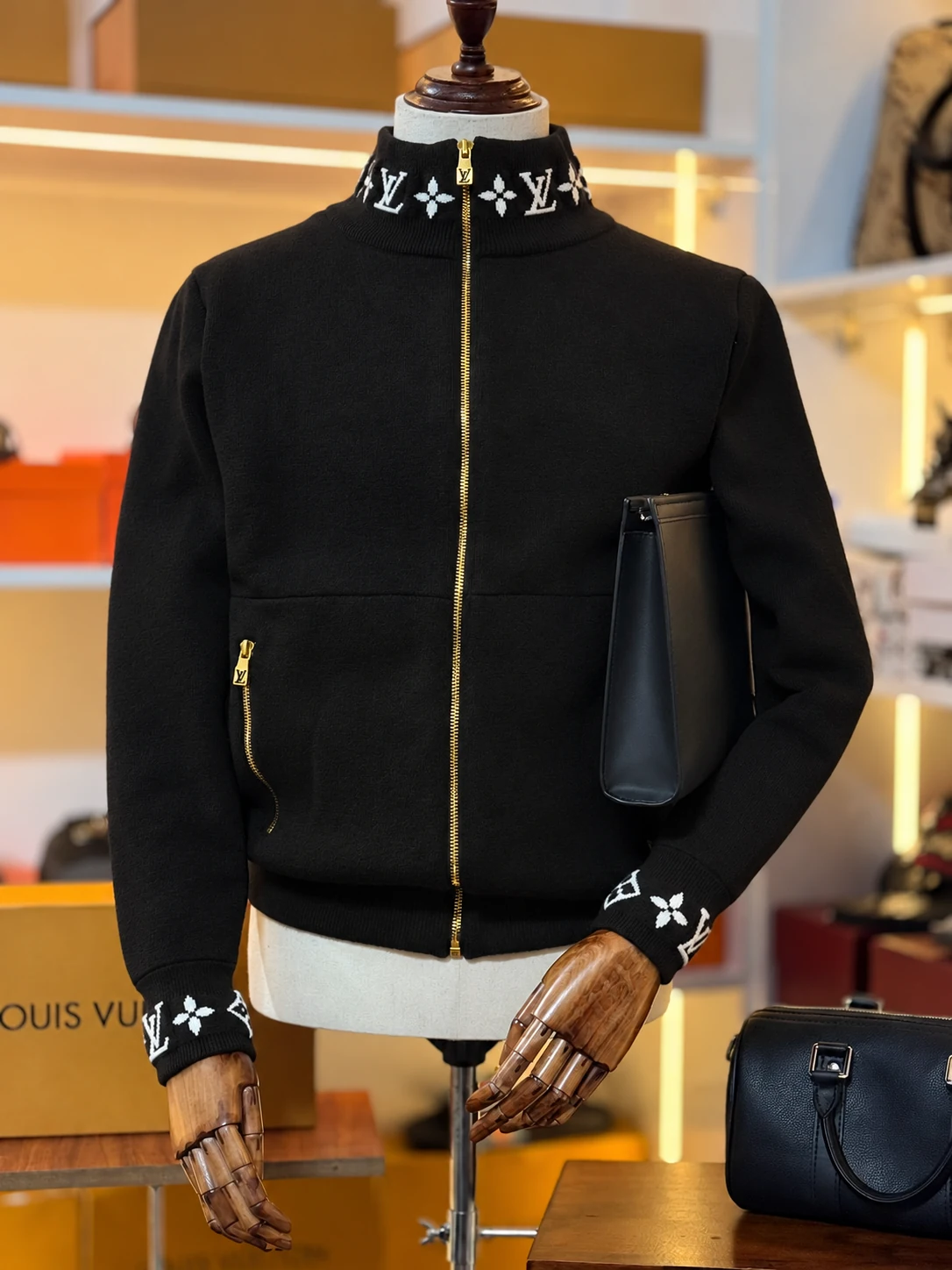 Áo khoác len đen cổ đứng, họa tiết Monogram trên mannequin trong không gian boutique
